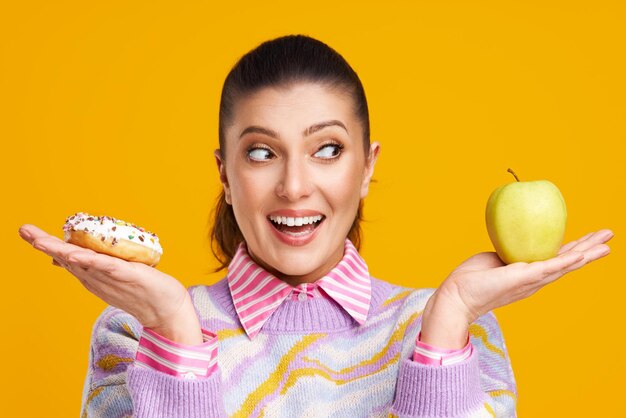 Young beautiful woman over yellow background with donuts High quality photo