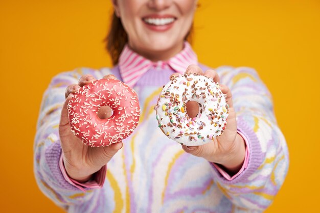 Young beautiful woman over yellow background with donuts High quality photo