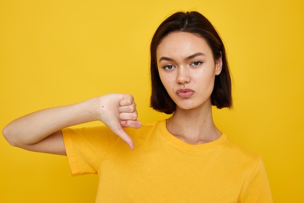 Young beautiful woman yellow tshirt summer style hand gesture isolated background