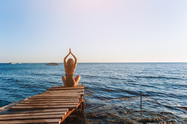 Young beautiful woman on yoga on the beach