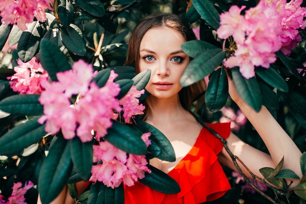 Giovane bella womanposing tra l'albero in fiore