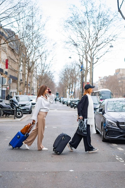 young beautiful women friends travel with suitcases. Paris. The concept of a happy travel photo.