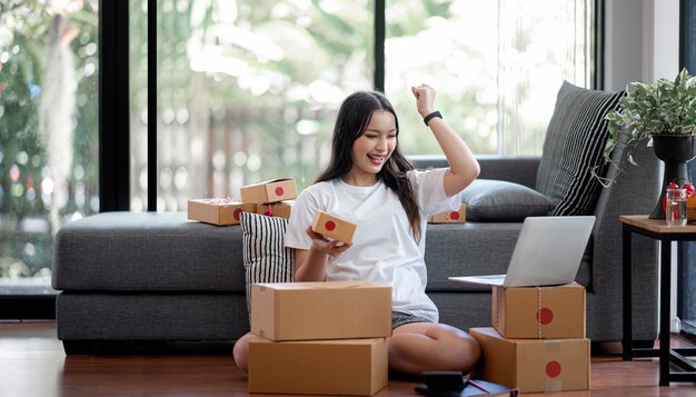 顧客からの新しい注文の後に幸せな若い美しい女性。