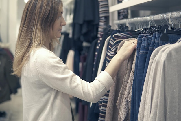 young beautiful women shopping in fashion mall, choosing new clothes.