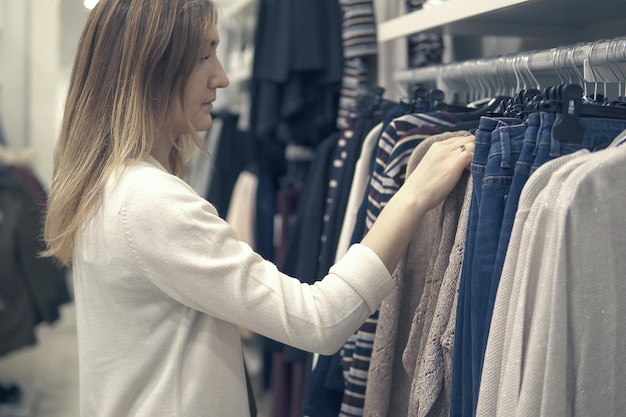 Young beautiful women shopping in fashion mall, choosing new clothes.