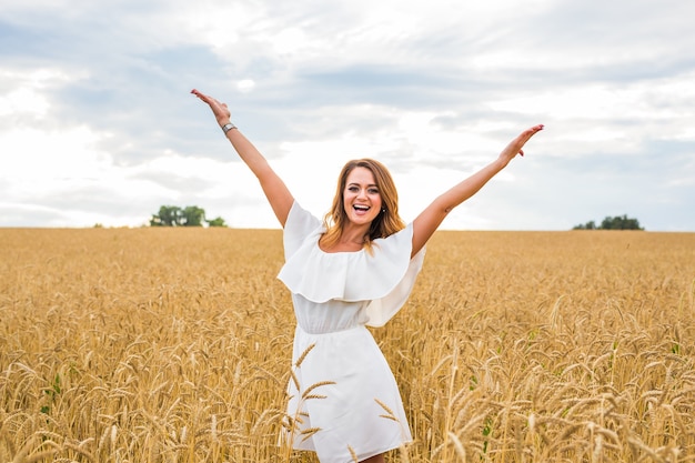 Young beautifull woman on a field with rye