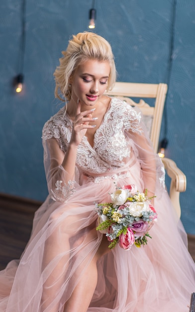 Young beauty fashion bride in winter decor with bouquet of flowers in her hands. Beautiful Bride portrait wedding makeup and hairstyle. 