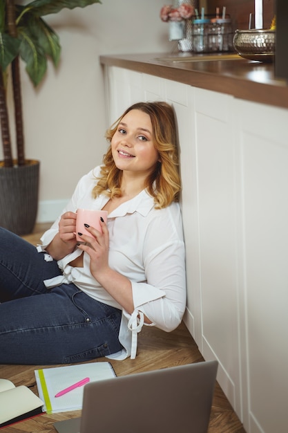 young beauty. joyful girl sitting on the floor while preparing for exams