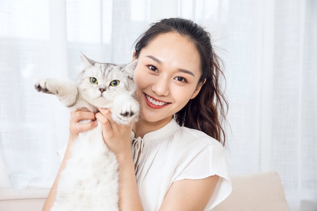 自宅で猫をなめる若い美しさ