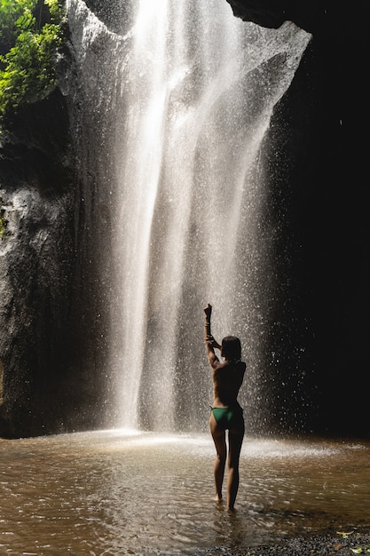 Young beauty. Pretty young woman standing in water in swimsuit, having shooting in exotic place