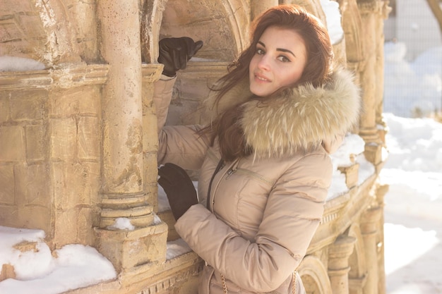 Young beauty woman in winter park in winter cold day