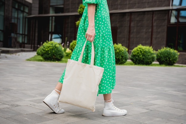 Young beautyful woman with linen eco bag on city background