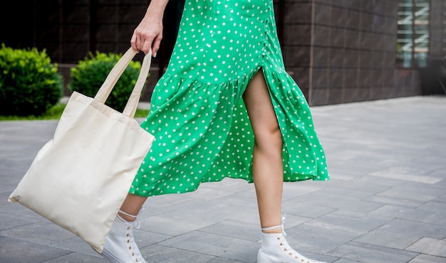 Young beautyful woman with linen eco bag on city background