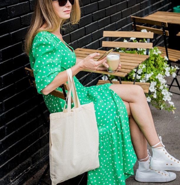 Young beautyful woman with linen eco bag on city\
background