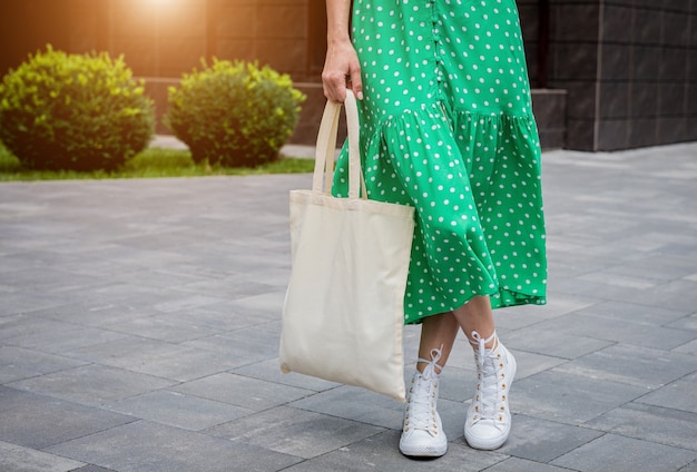 Young beautyful woman with linen eco bag on city background