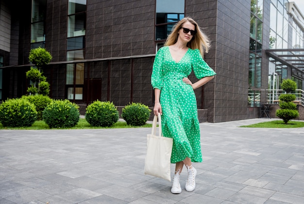 Young beautyful woman with linen eco bag on city background