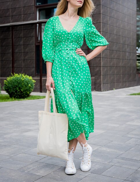 Young beautyful woman with linen eco bag on city\
background