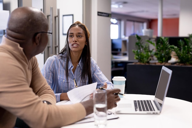 Photo young biracial businesswoman planning strategy with african american businessman at modern workplace