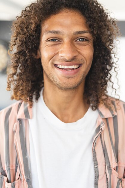 Photo young biracial man with curly brown hair smiles warmly