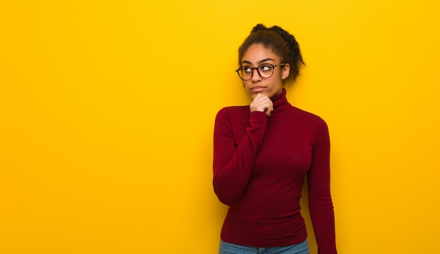 Photo young black african american girl with blue eyes doubting and confused