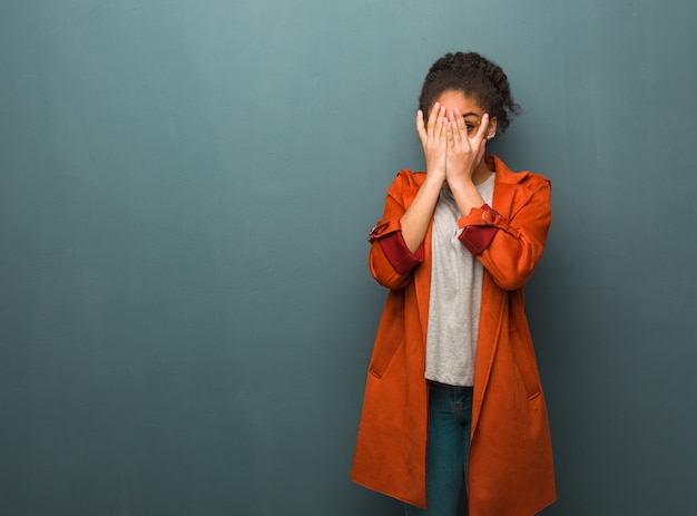 Young black african american girl with blue eyes feels worried and scared