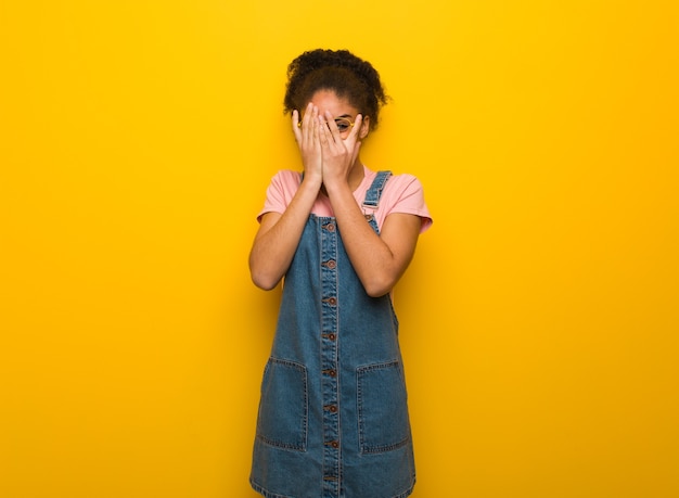 Young black african american girl with blue eyes feels worried and scared