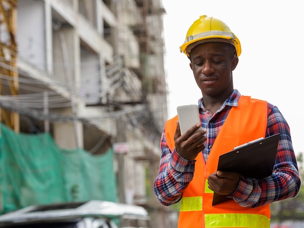 Young black African man construction worker holding clipboard