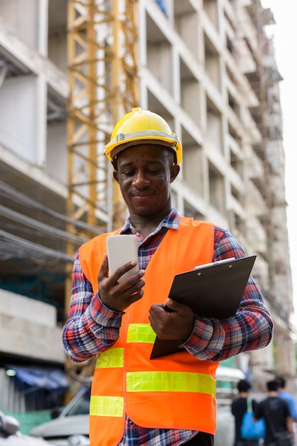 Young black African man construction worker holding clipboard