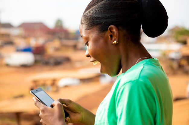 Young black african woman checking content on social media chatting with friend online using cellphone