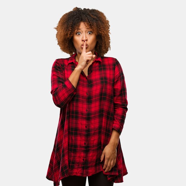 Photo young black afro woman keeping a secret or asking for silence