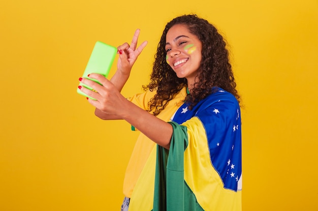 Young black brazilian soccer fan making self portrait in selfie smartphone