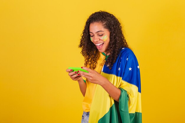 Young black brazilian soccer fan playing game smartphone