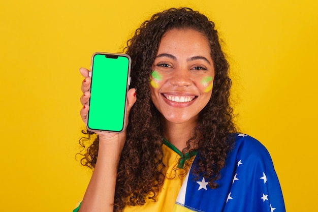 Young black brazilian soccer fan showing cellphone screen smartphone app mobile closeup photo