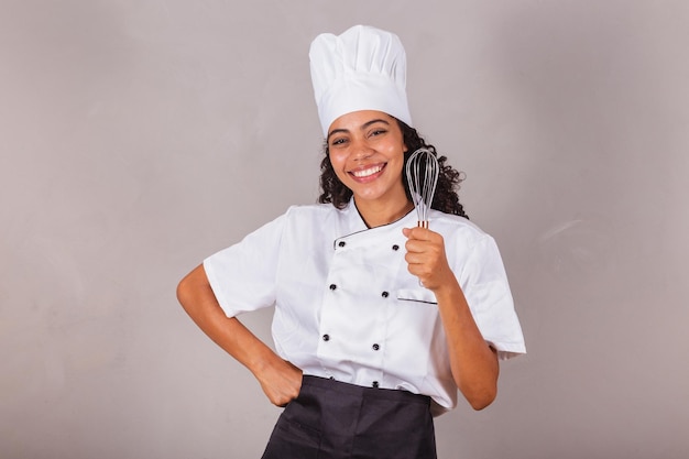 Photo young black brazilian woman cook masterchef holding fue preparing sweets