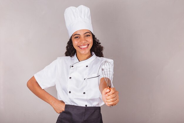 Young black brazilian woman cook masterchef holding fue preparing sweets