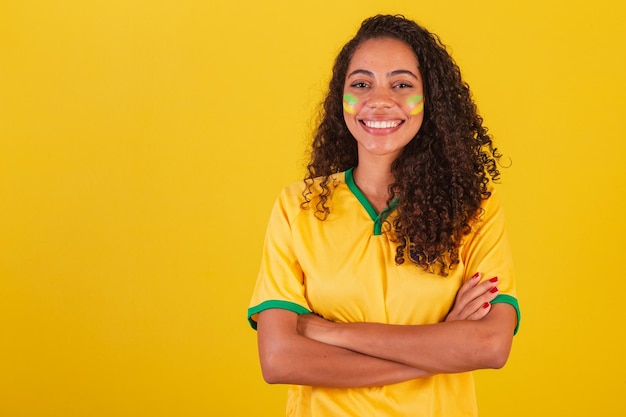 Young black brazilian woman soccer fan arms crossed over the body