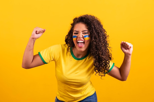 Young black brazilian woman soccer fan celebrating and celebrating