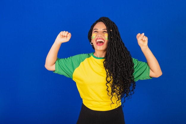 Young black Brazilian woman soccer fan celebrating and celebrating