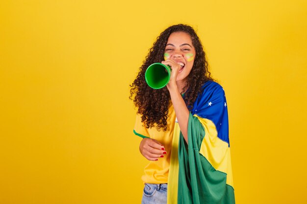 拡声器の広告写真を通して叫ぶ若い黒人ブラジル人女性サッカーファン