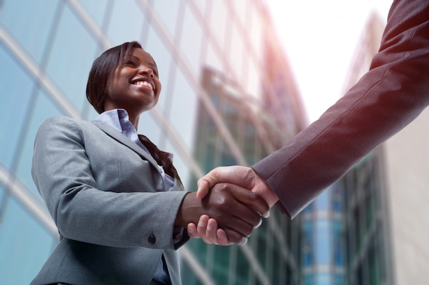 ビジネスの男性と握手する若い黒のビジネス女性