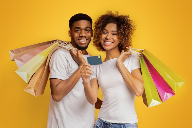 Young black couple with shopping bags and credit card