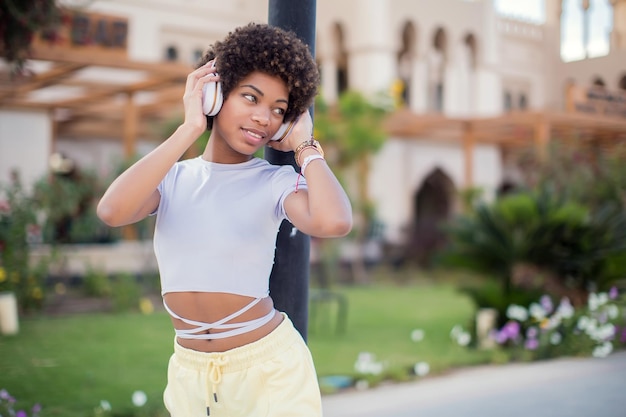 Young black girl listening to the music with headphones Lifestyle concept