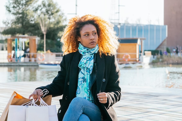 Foto giovane ragazza nera che si riposa in una giornata di shopping