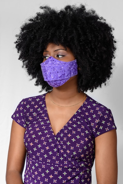 young black girl wearing face mask isolated on gray background