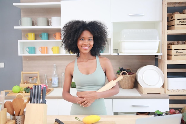 Young black girl with afro hair woman preparing and eating fruit before making a smoothie