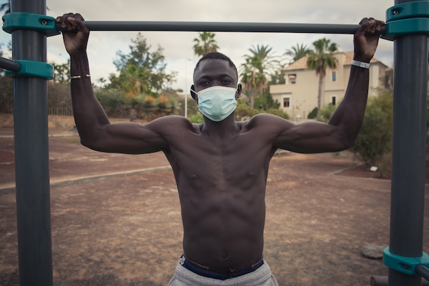 Young black man exercises with face mask outdoors