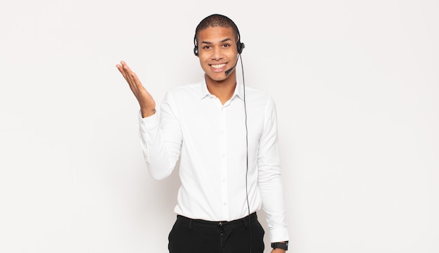 Young black man feeling happy, surprised and cheerful, smiling with positive attitude, realizing a solution or idea