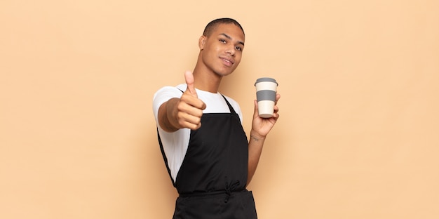 Young black man feeling proud, carefree, confident and happy, smiling positively with thumbs up