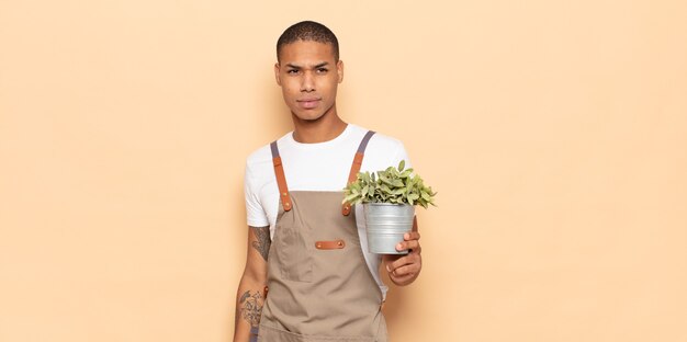 Young black man feeling sad, upset or angry and looking to the side with a negative attitude, frowning in disagreement