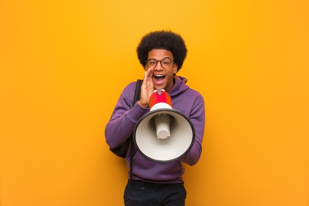 Photo young black man holdinga a megaphone shouting something happy to the front